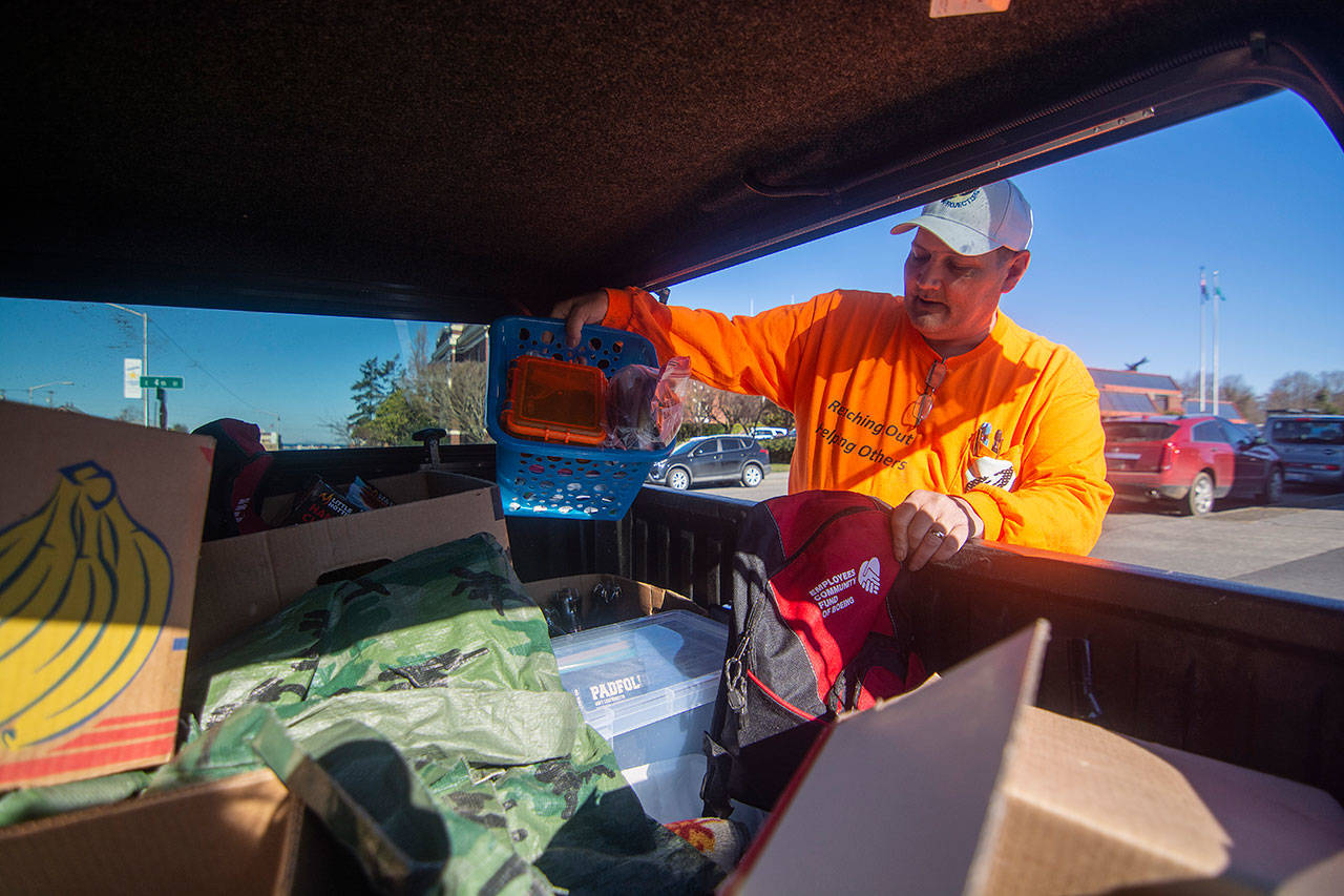 Robert Smiley, founder of The Hand Up Project, sorts through supplies in the back of his truck. (Jesse Major/Peninsula Daily News)