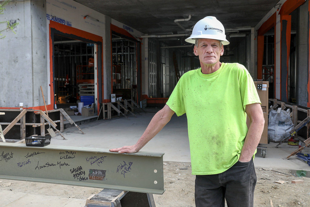 Graduate of HopeWorks internship program, Michael DeRogatis, proudly signed the final beam. (Lizz Giordano / The Herald)
