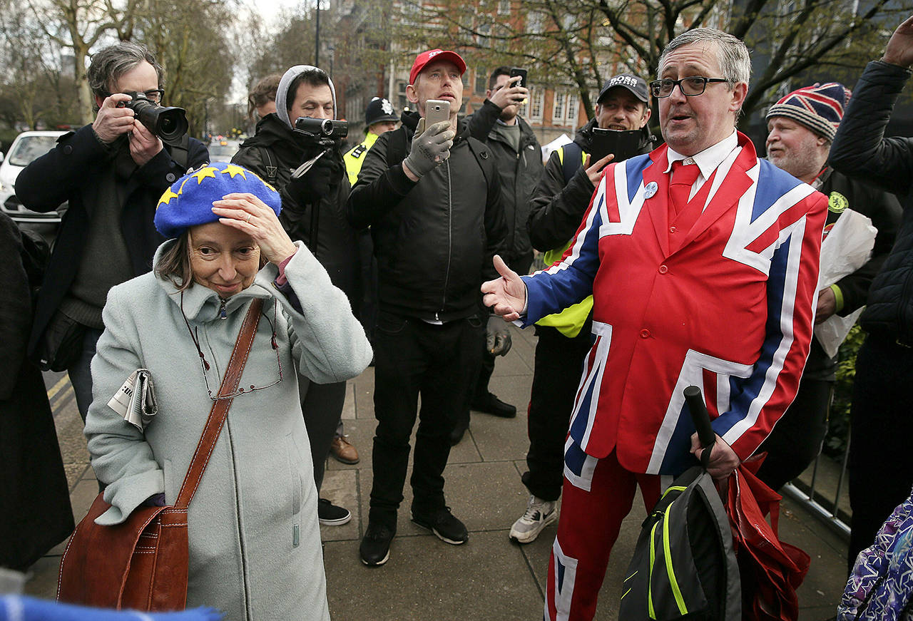 An anti-Brexit (left) and pro-Brexit supporter debate outside the House of Parliament in London on Tuesday. (AP Photo/Tim Ireland)