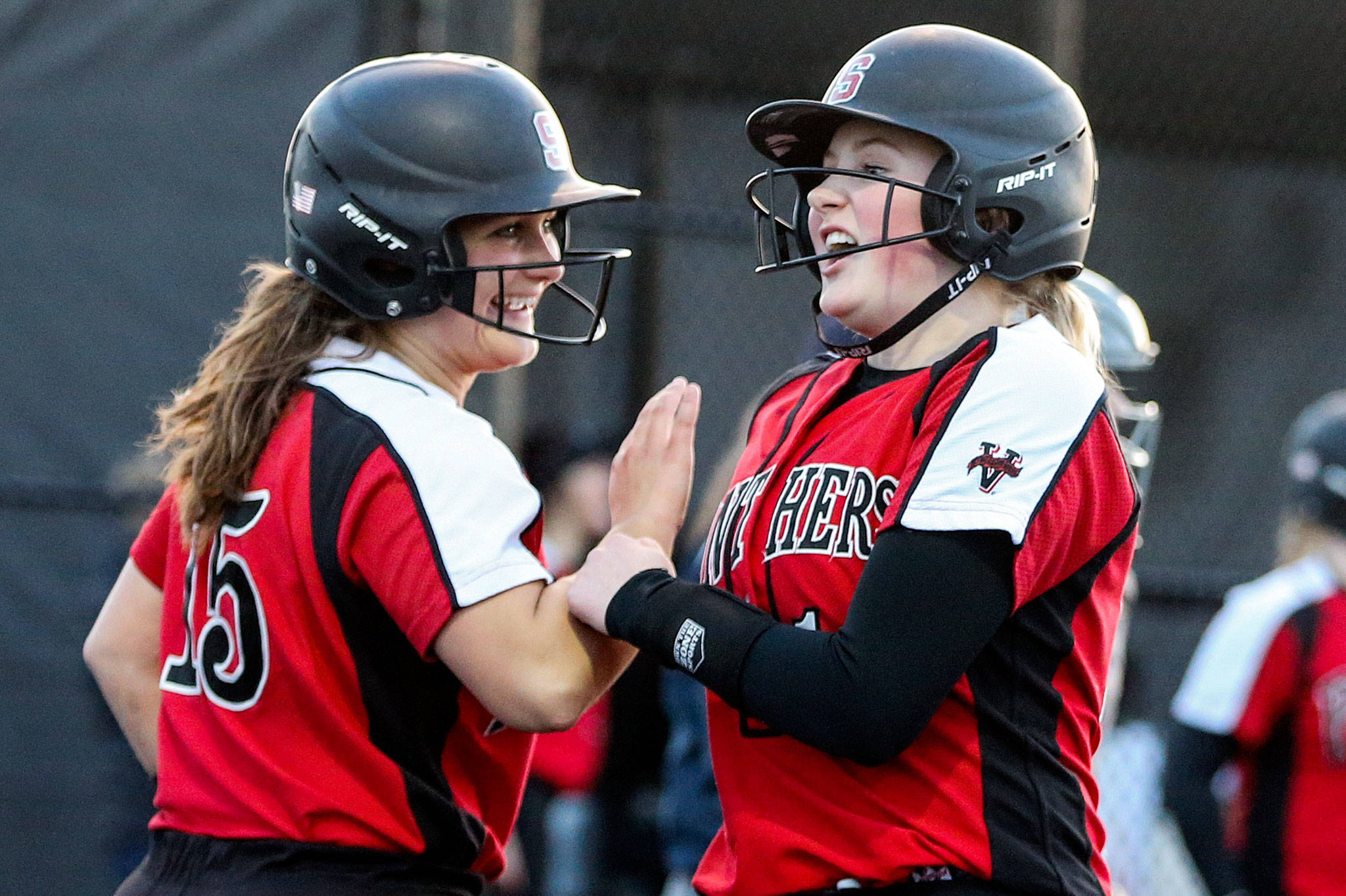 Anna Robinson (left) and Delaney Kaysner celebrate after scoring during Snohomish’s 10-run fourth inning. The visiting Panthers rolled to a 13-3 win over Monroe in five innings Wednesday night. (Kevin Clark / The Herald)