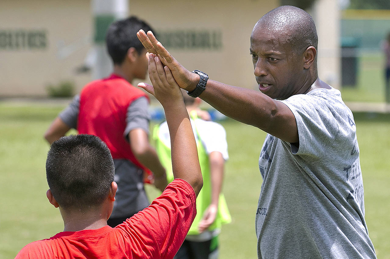 In a September 2016 photo, Yale’s women’s Head Soccer Coach Rudy Meredith gives a high five to a player in Frankfort, Kentucky. According to the federal indictments unsealed Tuesday, Meredith put a prospective student who didn’t play soccer on a school list of recruits, doctored her supporting portfolio to indicate she was a player, and later accepted $400,000 from the head of a college placement company. (Doug Engle/Star-Banner via AP, file)