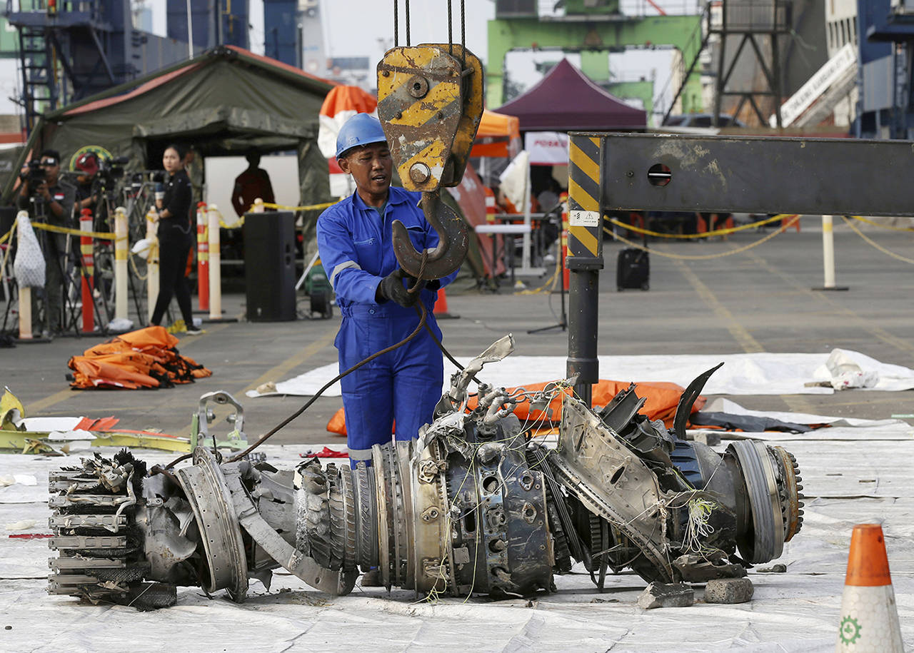 In this Nov. 4, 2018 photo, officials move an engine recovered from the crashed Lion Air jet for further investigation in Jakarta, Indonesia. (AP Photo/Achmad Ibrahim, File)