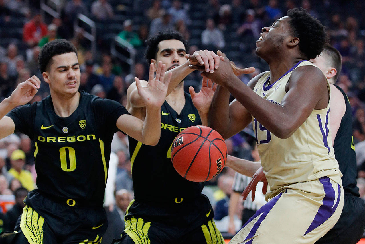 Oregon’s Will Richardson (left) and Ehab Amin guard Washington’s Noah Dickerson during the Pac-12 championship game on March 16, 2019, in Las Vegas. (AP Photo/John Locher)