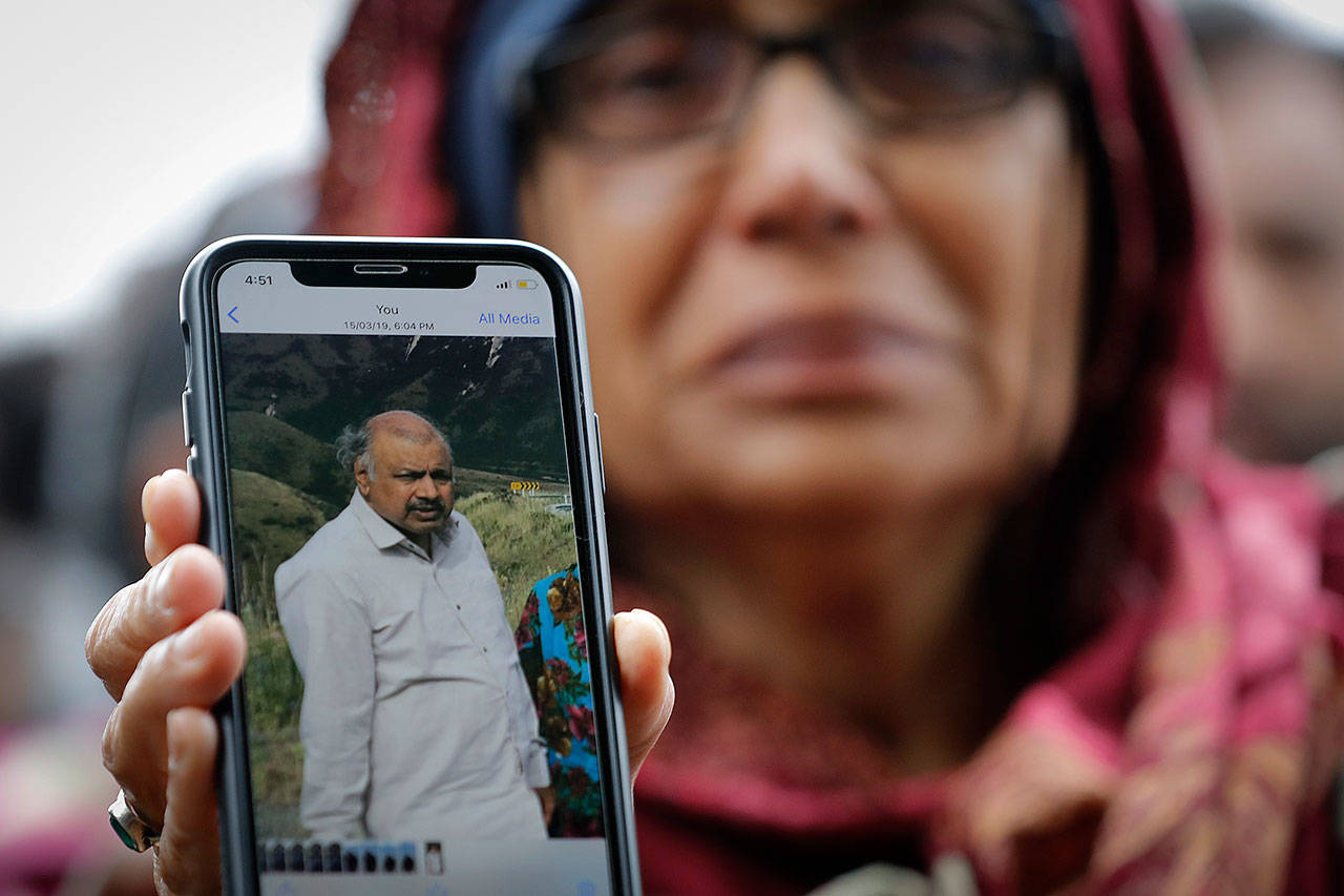 Akhtar Khokhur, 58, shows a picture of her missing husband Mehaboobbhai Khokhar during an interview outside an information center for families Saturday in Christchurch, New Zealand. (AP Photo/Vincent Thian)