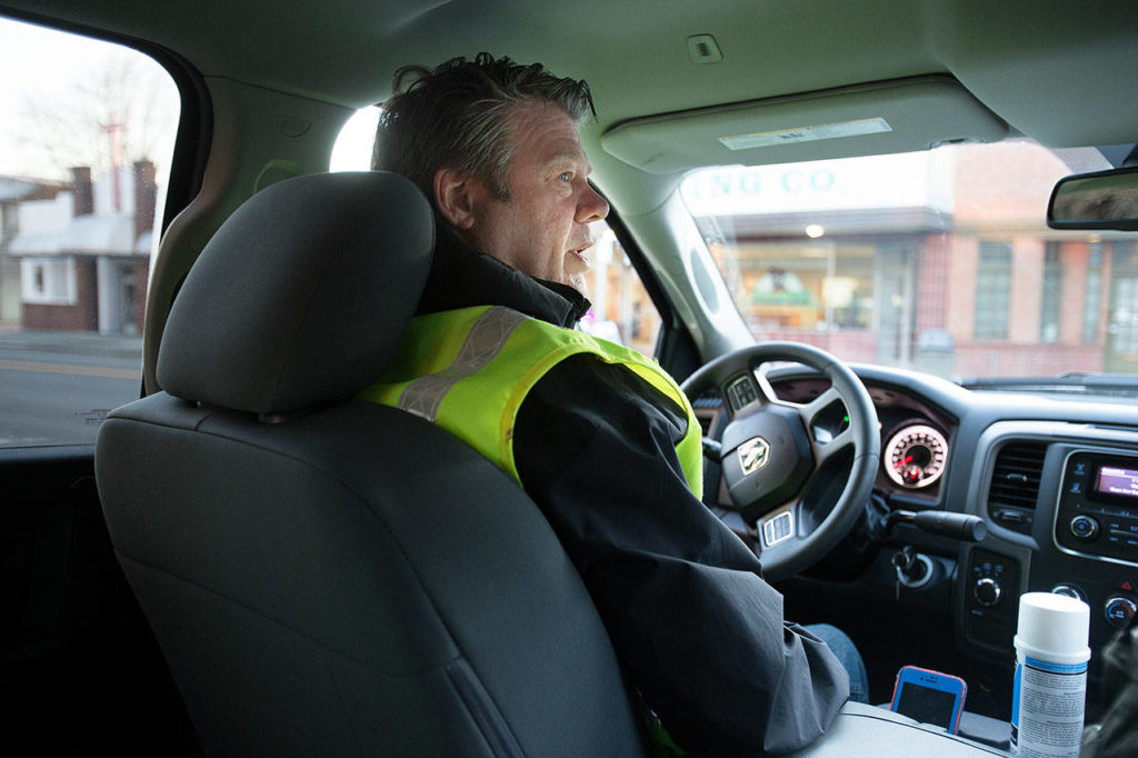 In a white pickup, Rich Webber looks for graffiti and trash as he cruises through the streets and alleyways downtown on Monday, March 18, 2019 in Everett, Wash. (Andy Bronson / The Herald)
