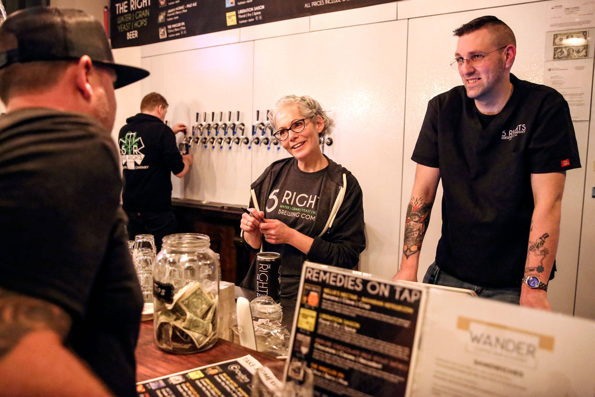 Kristi Whitlow (center) and Sean Seifert (right) take an order during the soft opening of 5 Rights Brewing. (Kevin Clark / The Herald)