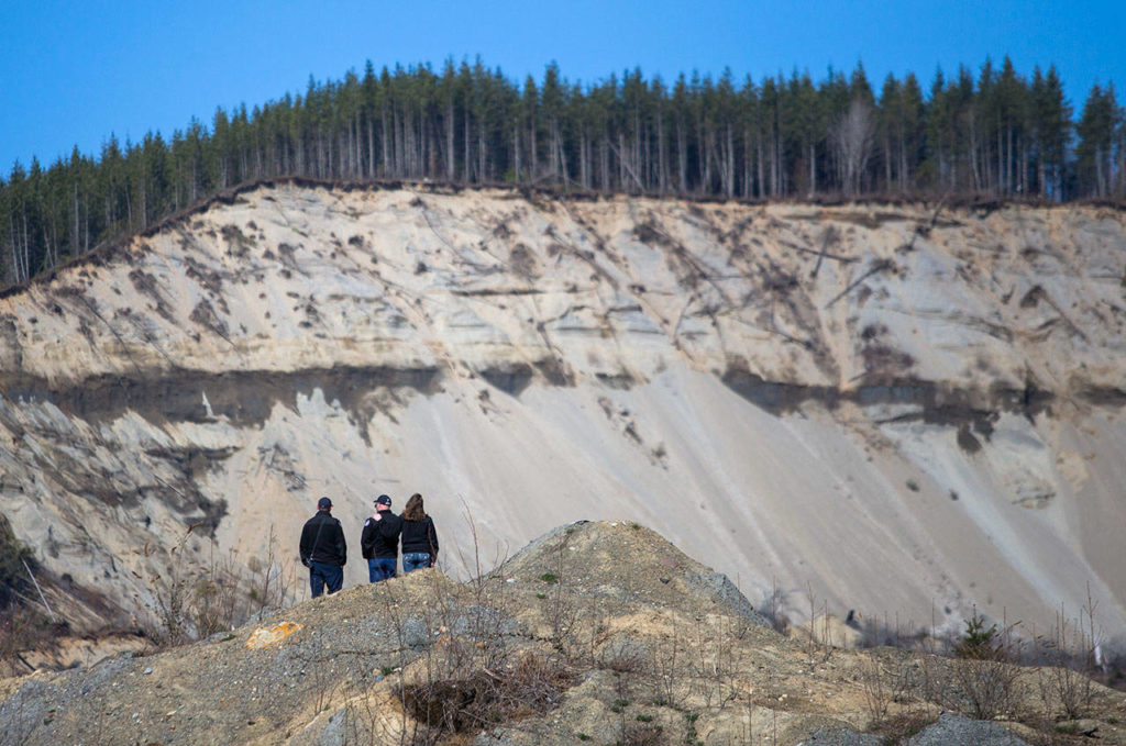 People view the 2014 mudslide site after a remembrance ceremony on Friday near Oso. (Olivia Vanni / The Herald)
