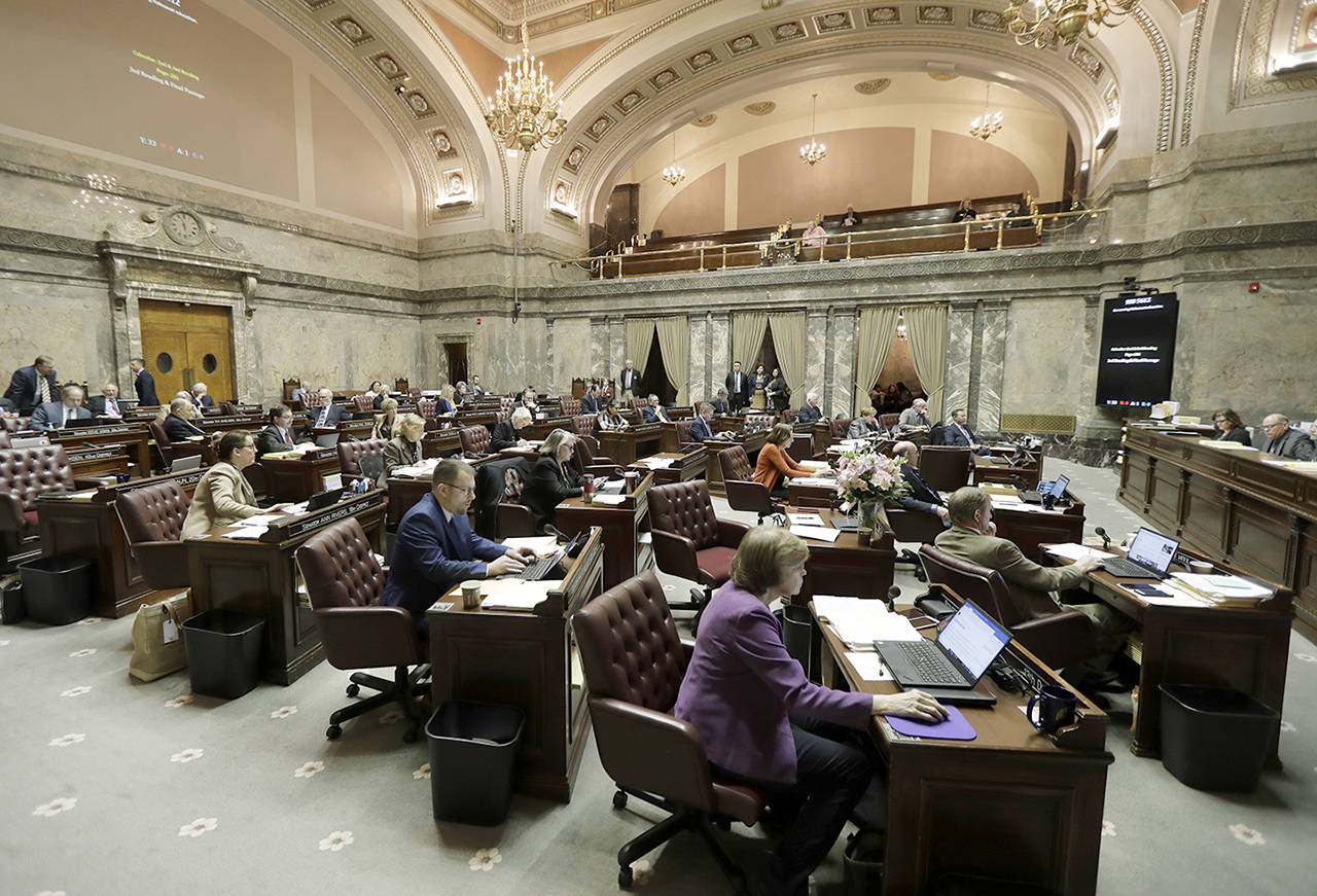 In this March 12 photo, Washington state Senators work on the Senate floor at the Capitol in Olympia. (AP Photo/Ted S. Warren)