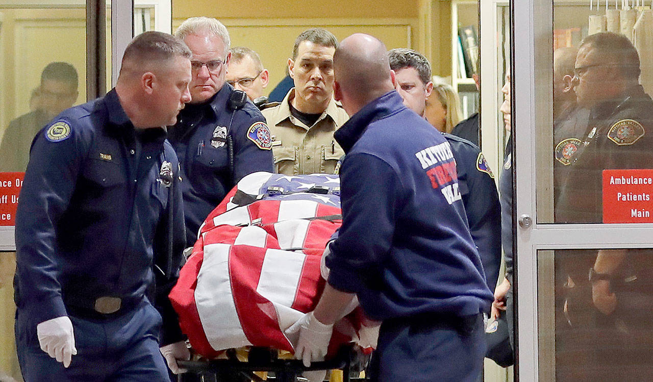 The body of a Kittitas County Sheriff’s deputy, draped with a U.S. flag, is carried out of Kittitas Valley Hospital in Ellensburg early Wednesday. The deputy was killed and a police officer was injured after an exchange of gunfire during an attempted traffic stop. (AP Photo/Ted S. Warren)