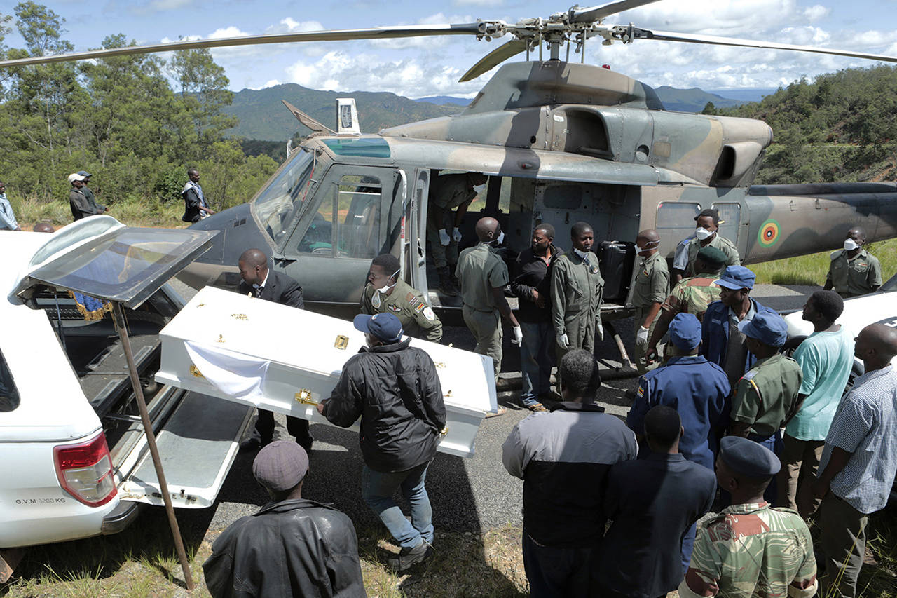 Rescuers carry a body from a military helicopter into a waiting hearse in Chimanimani, about 600 km south east of Harare, Zimbabwe, on Wednesday. Hundreds are dead, many more missing and thousands at risk from massive flooding in Mozambique, Malawi and Zimbabwe caused by Cyclone Idai. (AP Photo/Tsvangirayi Mukwazhi)