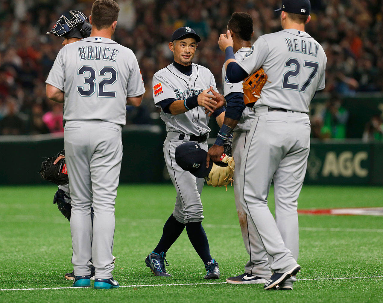 Seattles Ichiro Suzuki (center) greets teammates while leaving the field after being subsituted in the fourth inning of the Mariners 9-7 win over Oakland on Wednesday in Tokyo. (AP Photo/Toru Takahashi)
