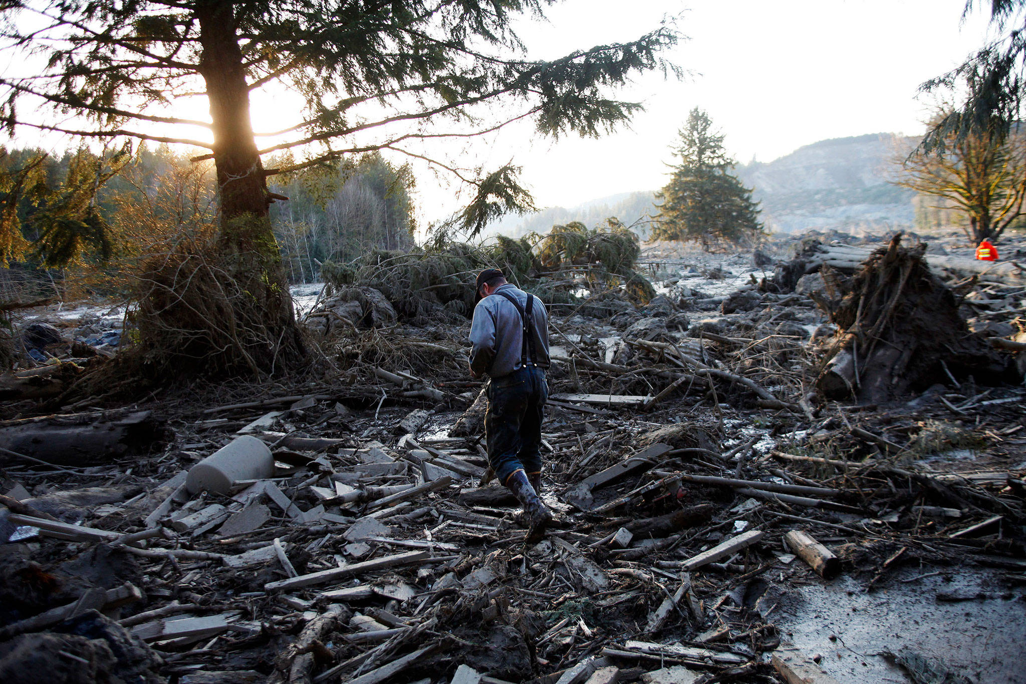 Steve Skaglund walks across the rubble a day after the fatal mudslide near Oso. (Genna Martin / The Herald)