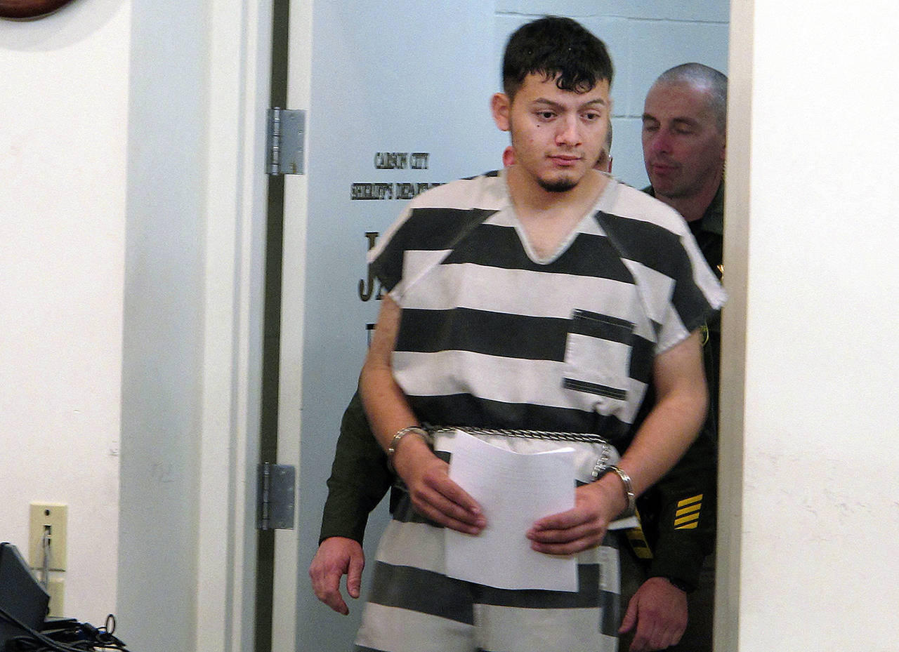 In this 2019 photo, Wilber Ernesto Martinez-Guzman, 19, of El Salvador, is escorted into the courtroom for his initial appearance in Carson City Justice Court in Carson City, Nevada. (AP Photo/Scott Sonner, File)