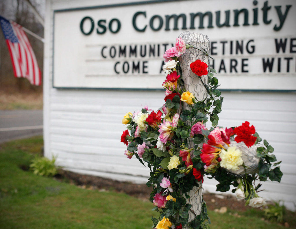 A cross is decorated with flowers in dedication of mudslide victims at the Oso Community Chapel on March 26, 2014. (Sofia Jaramillo / The Herald)
