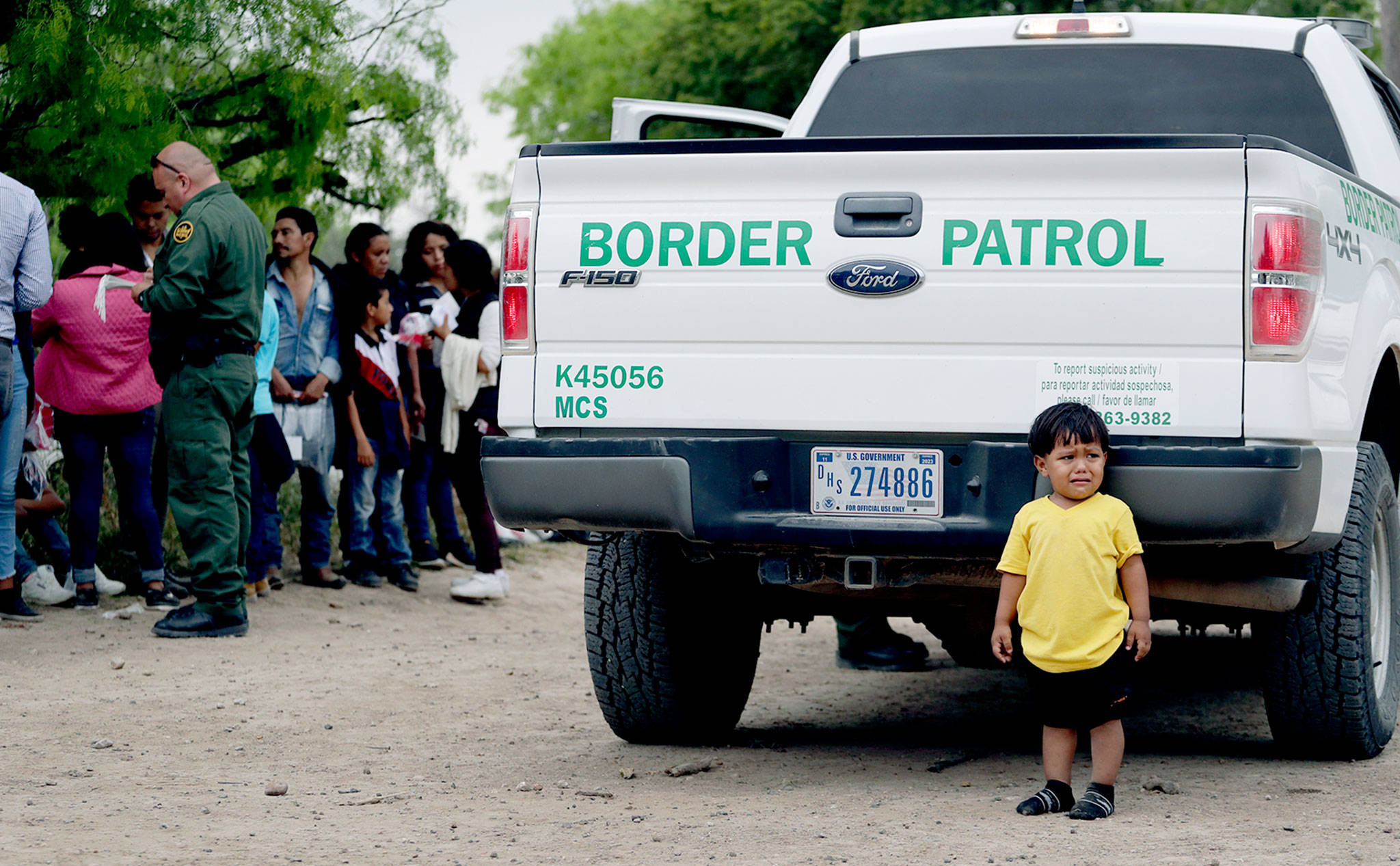 William Josue Gonzales Garcia, 2, who was traveling with his parents, waits with other families who crossed the nearby U.S.-Mexico border near McAllen, Texas, last week. (AP Photo/Eric Gay)