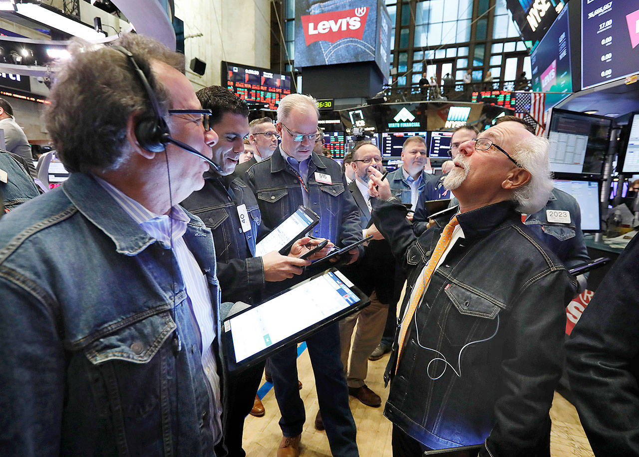 People work on the trading floor of the New York Stock Exchange on Thursday. The “No Blue Jeans” rule was relaxed on the trading floor for the listing of Levi Strauss. The company, which gave America its first pair of blue jeans, is public again, for the second time. (AP Photo/Richard Drew)