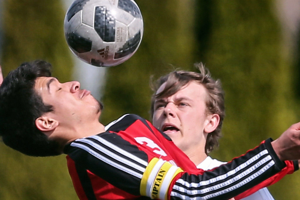 Marysville Pilchuck’s Edgar Martinez works to control the ball, with Snohomish’s Owen Fielder closing in. (Kevin Clark / The Herald)
