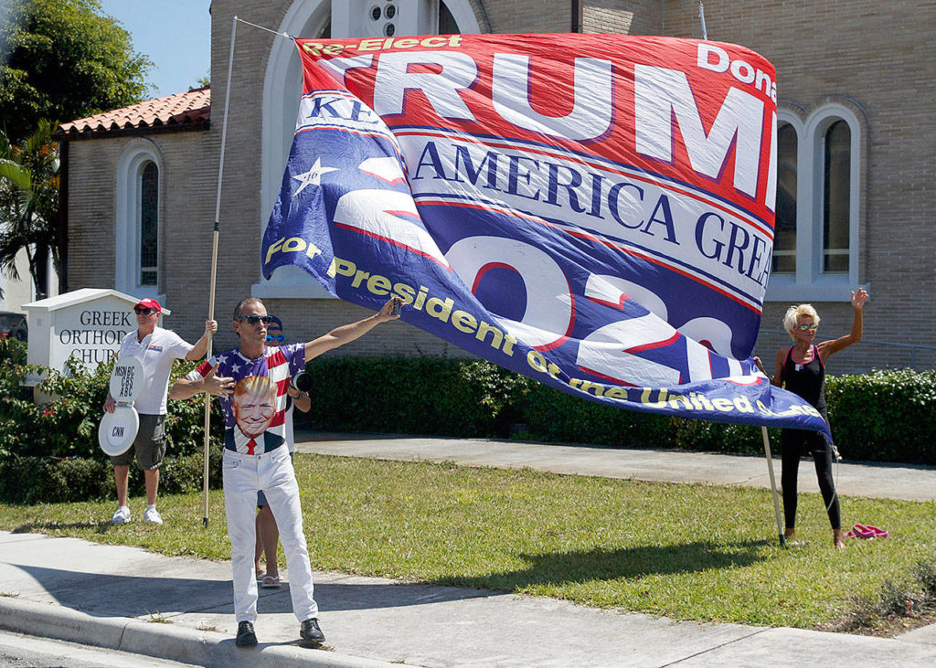 Supporters of President Donald Trump are seen from the media van in the motorcade accompanying the president in West Palm Beach, Fla., Saturday, March 23, en route to Mar-a-Lago in Palm Beach. (AP Photo/Carolyn Kaster)
