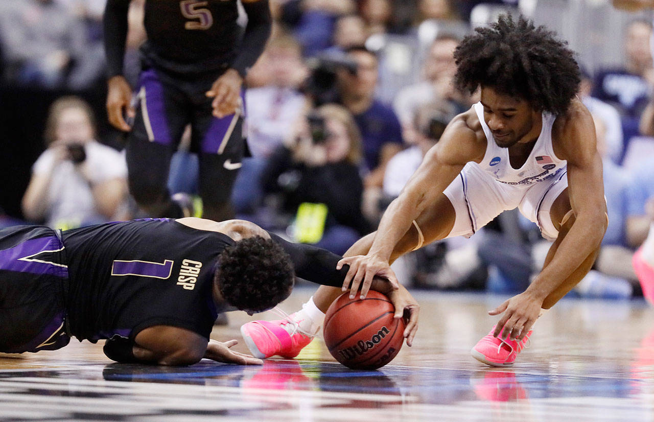 Washington’s David Crisp (1) and North Carolina’s Coby White (2) battle for a loose ball in the first half of Sunday’s game in Columbus, Ohio. (AP Photo/John Minchillo)