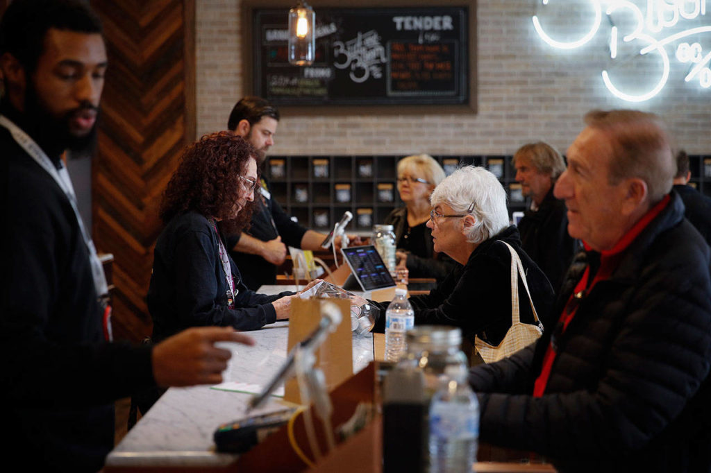 A group of seniors from Laguna Woods Village consult with sales associates at Bud and Bloom cannabis dispensary in Santa Ana, California, on Feb. 19. The seniors boarded a bus for the pot shop and spent hours choosing from a variety of cannabis-infused products, including candies, drinks and weed. (AP Photo/Jae C. Hong)
