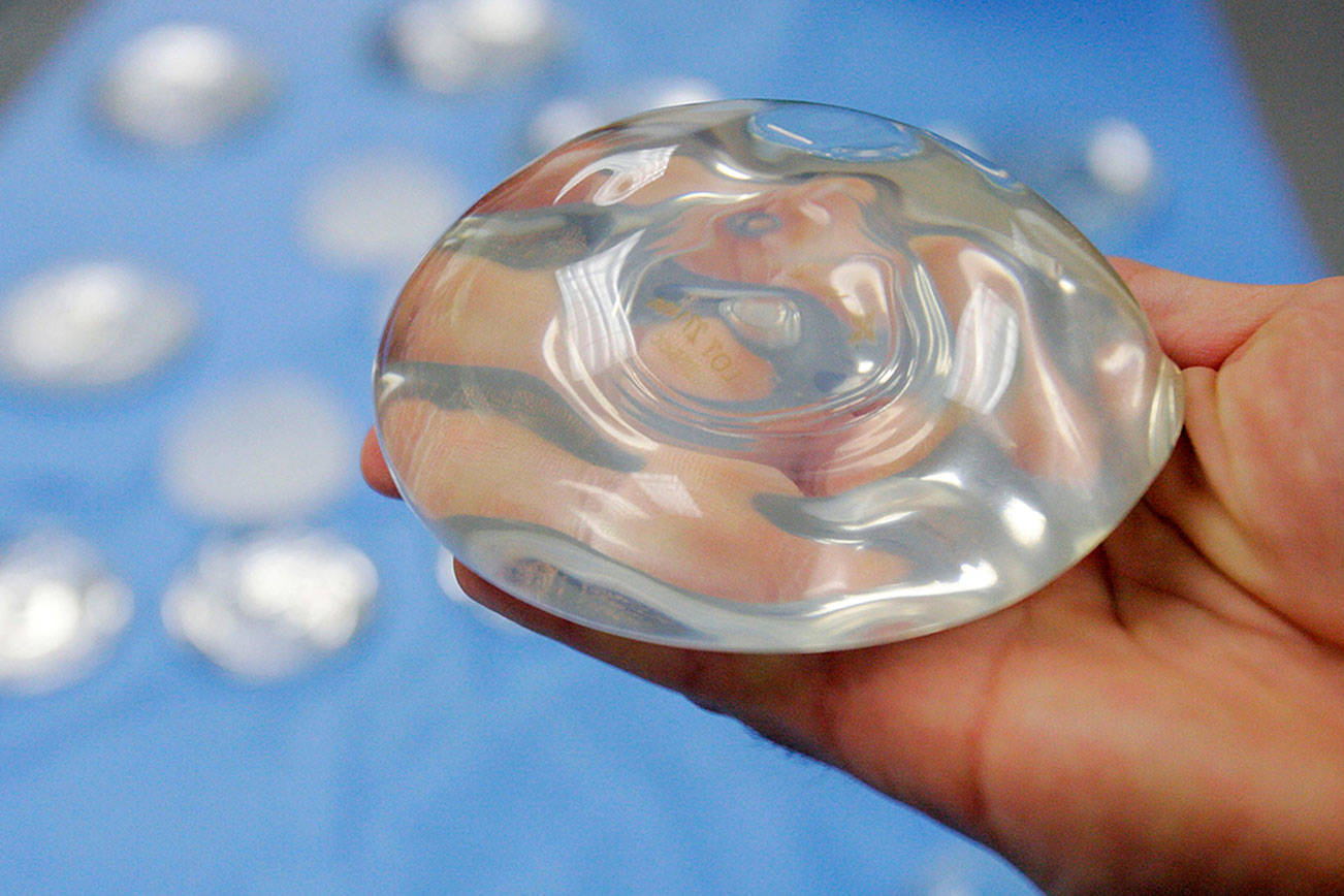 U.S. health officials are taking another look at the safety of breast implants, the latest review in a decades-long debate. At a two-day meeting that starte Monday, a panel of experts for the U.S. Food and Drug Administration will hear from researchers, plastic surgeons and implant makers, as well as from women who believe their ailments were caused by the implants. (AP Photo/Donna McWilliam, File)