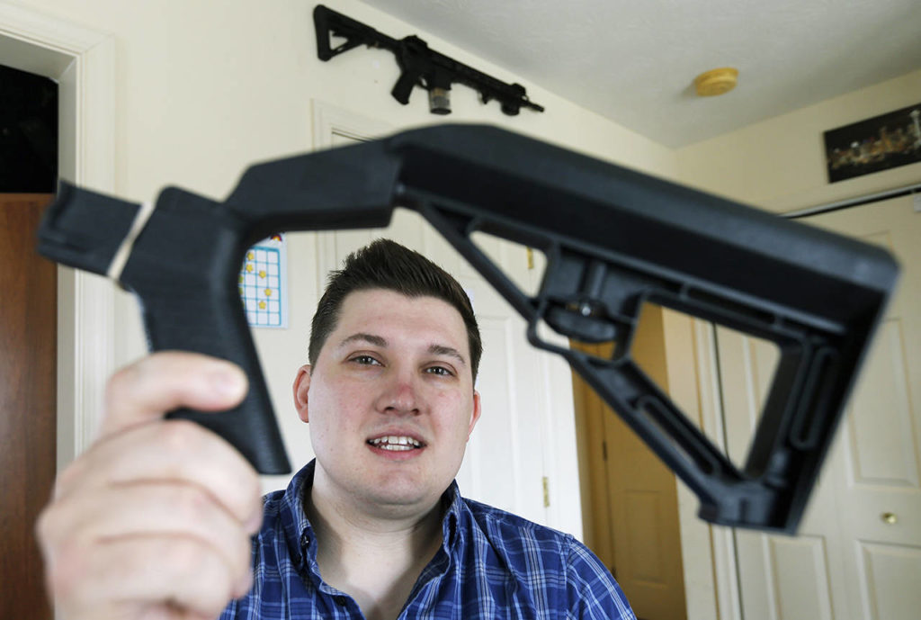 In this March 15 photo, Ryan Liskey displays a bump stock at his home in Harrisonburg, Virginia. (AP Photo/Steve Helber)
