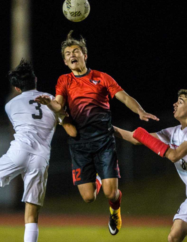 Stanwood’s Shintaro Wilcox (center) jumps for a header. (Olivia Vanni / The Herald)

