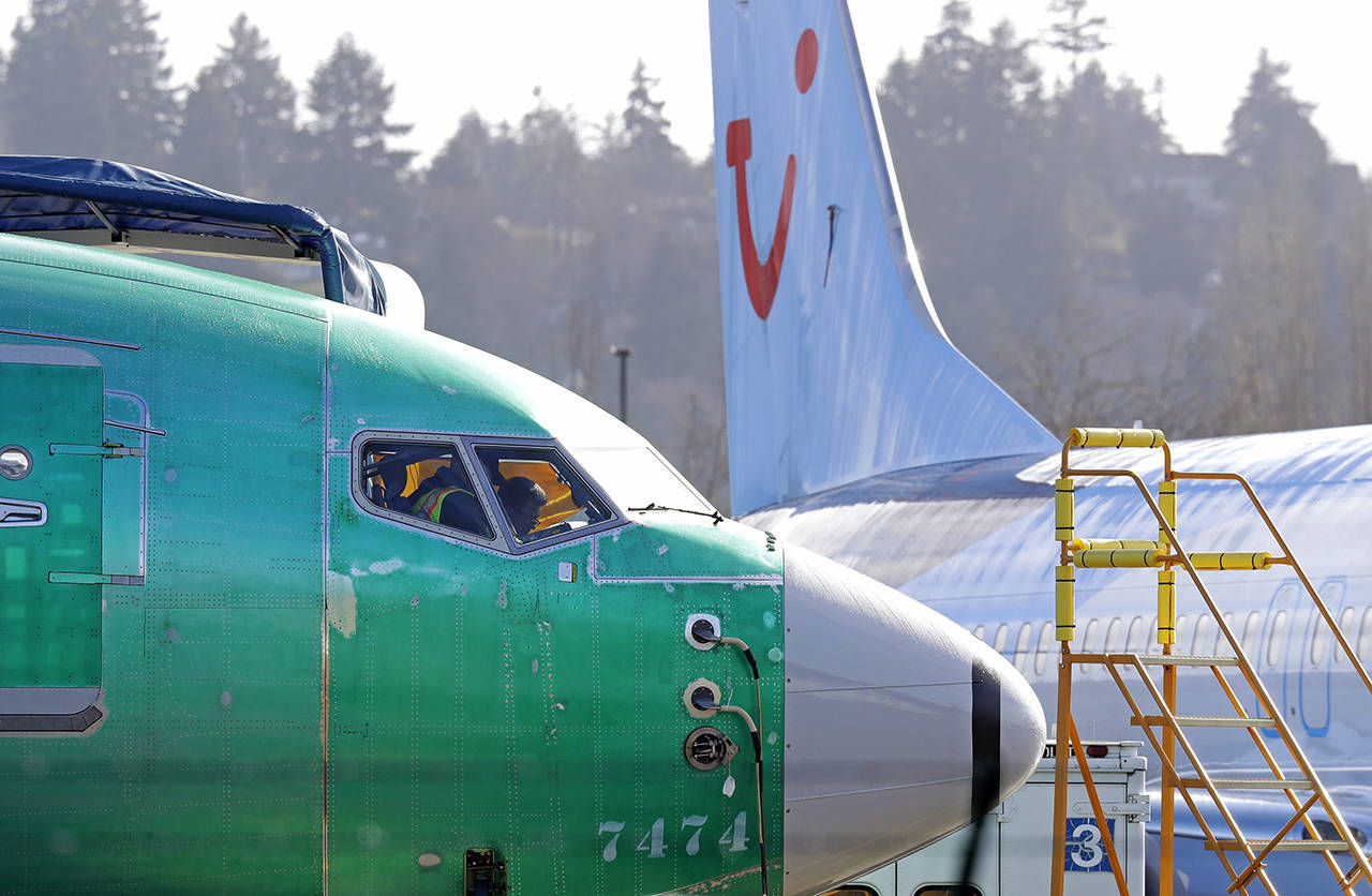 In this March 13 photo, people work in the flight deck of a Boeing 737 MAX 8 airplane being built for TUI Group parked next to another MAX 8 also designated for TUI at Boeing Co.’s Renton Assembly Plant. (AP Photo/Ted S. Warren, File)