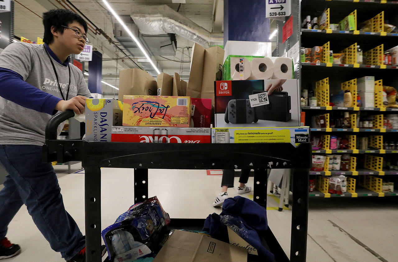 Wilson Yu fills an Amazon Prime order at the warehouse in SoDo. He is one of scores of people who have found work with Amazon through Northwest Center since 2015. (Alan Berner/The Seattle Times/TNS)