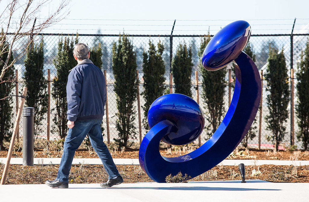 A man looks at the sculpture titled “Aurora” as he walks by at the new terminal at Paine Field on March 18 in Everett. (Andy Bronson / The Herald)
