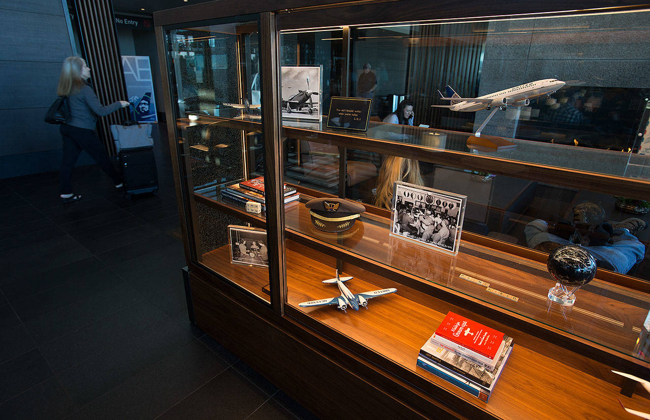 A passenger walks by a display case in the departure gate area filled with memorabilia on March 18 in Everett. (Andy Bronson / The Herald)