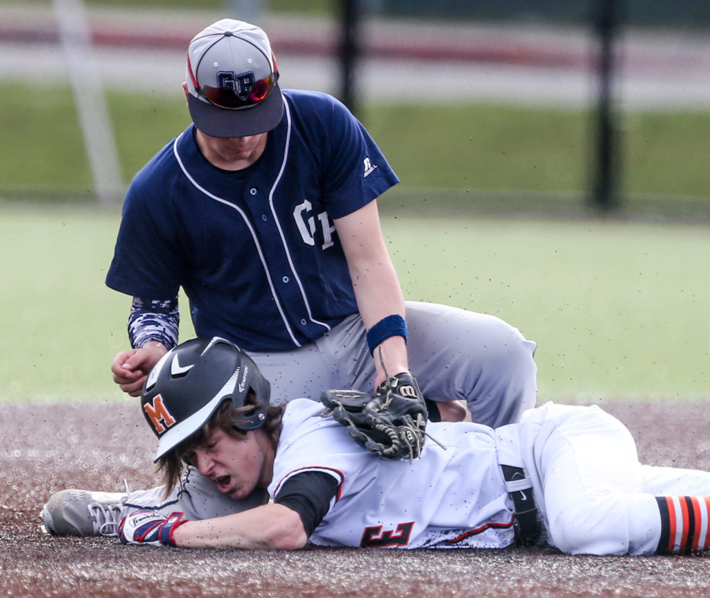 Glacier Peak’s Nathan Tastad attempts to tag out Monroe’s Gage Kirsch on his retreat to second base Wednesday afternoon at Monroe High School on March 27, 2019. The Bearcats won 9-1. (Kevin Clark / The Herald)
