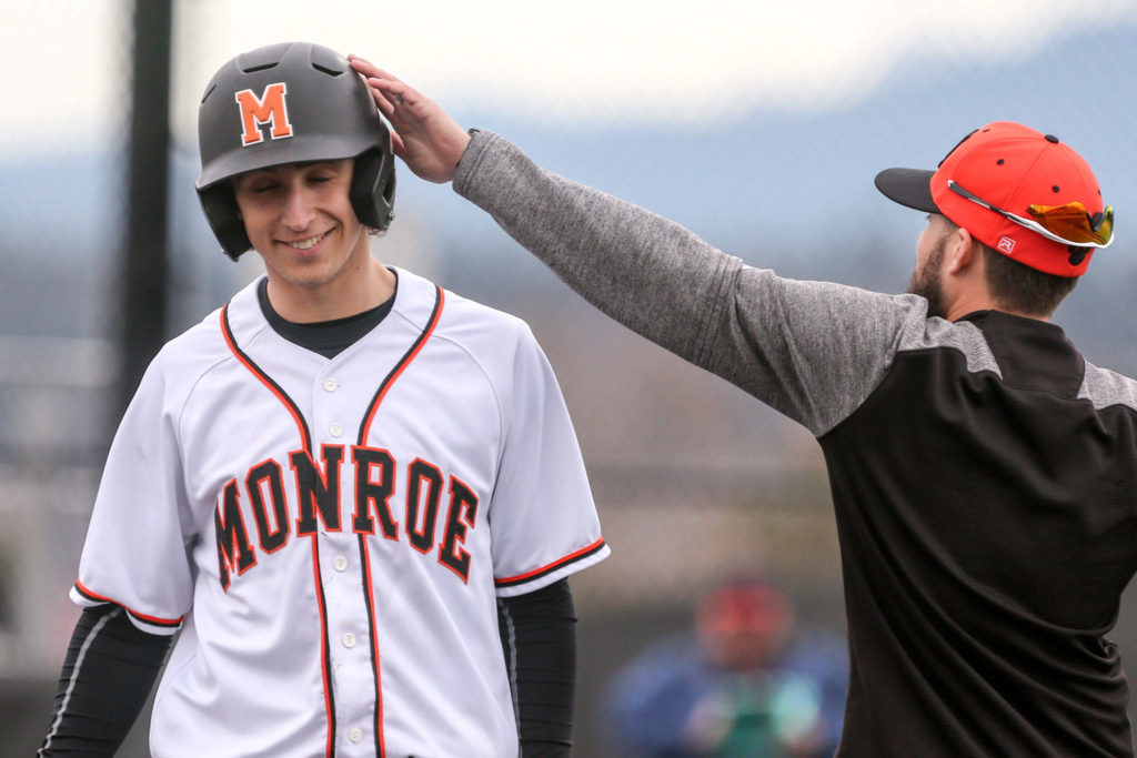 Monroe’s Morgan Granich get a head pat after scoring a run against Glacier Peak Wednesday afternoon at Monroe High School on March 27, 2019. The Bearcats won 9-1. (Kevin Clark / The Herald)
