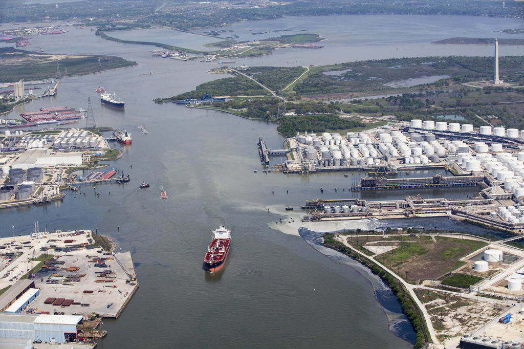 Maritime traffic moves through the Houston Ship Chanel past the site of now-extinguished petrochemical tank fire at Intercontinental Terminals Company in Deer Park, Texas, on March 20. Air quality and water pollution from the fire’s runoff, seen on the right, into the ship channel are some of the concerns in the aftermath of the blaze. (Brett Coomer/Houston Chronicle via AP, file)
