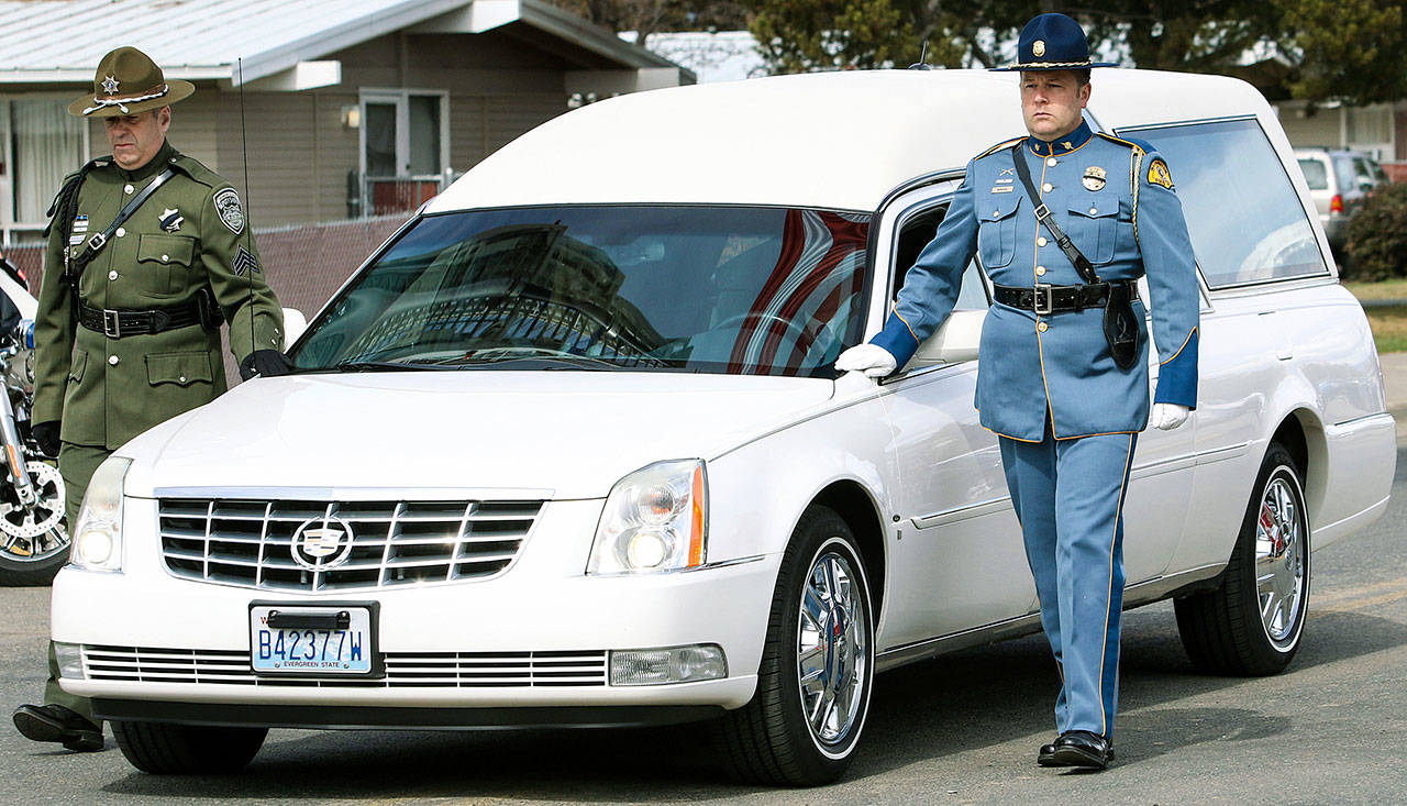 A hearse bearing the body of Kittitas County Deputy Sheriff Ryan Thompson arrives ahead of a memorial service Thursday at Central Washington University in Ellensburg. Hundreds of law enforcement officers from throughout the region have gathered for a memorial service for Thompson, who was shot to death by a road rage suspect last week. (Jake Green/The Daily Record via AP)