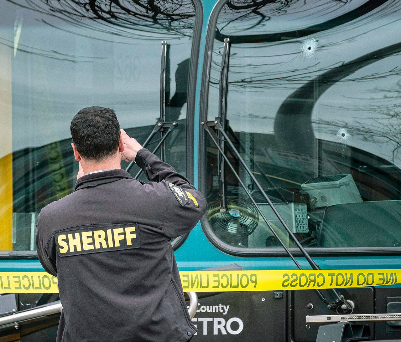 Several bullet holes can be seen in the driver’s side window of a Metro Bus on Northeast 125th Street, between 32nd and 33rd Avenues Northeast, after a shooting Wednesday in Seattle. (Dean Rutz/The Seattle Times via AP)