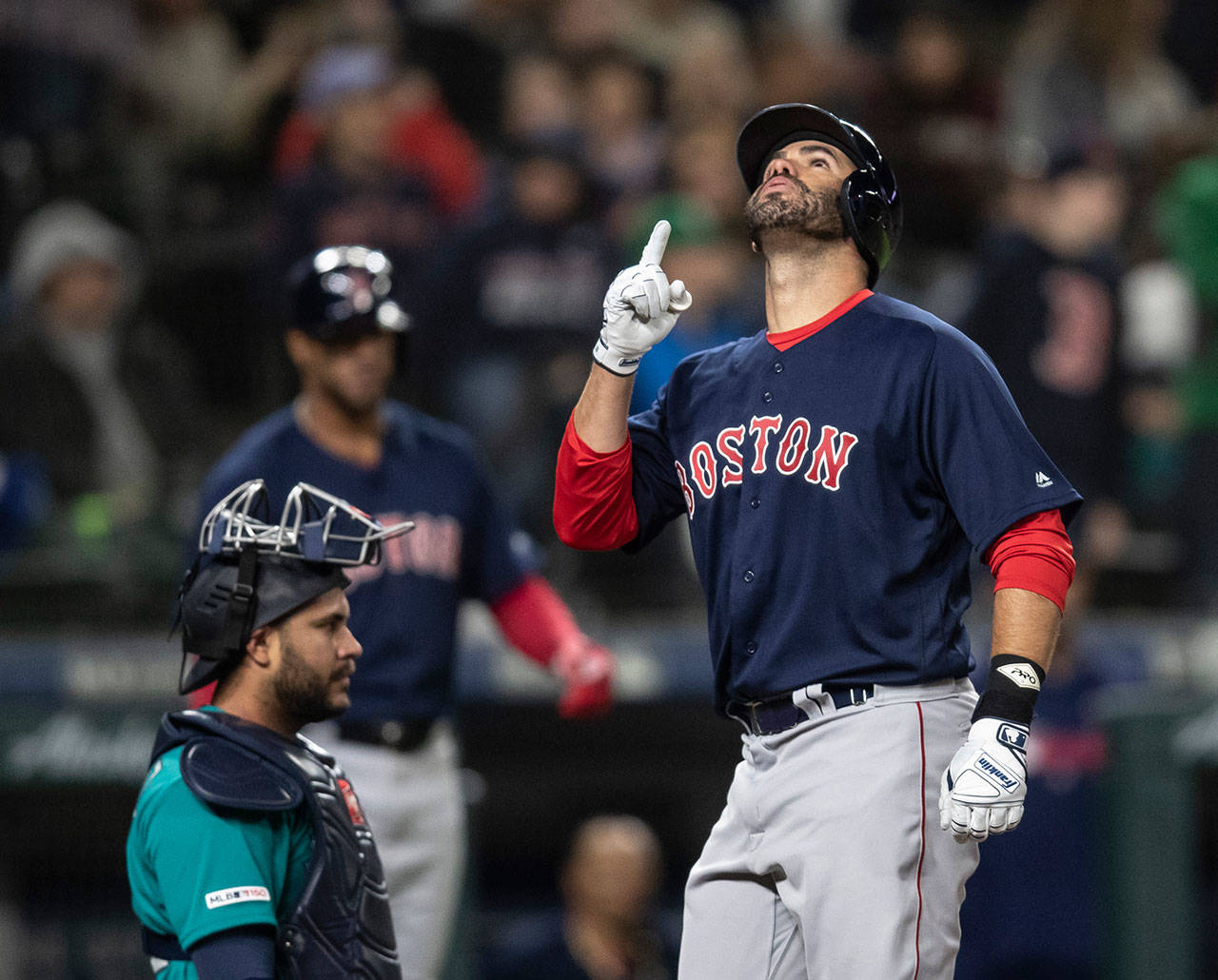 The Red Sox’s J.D. Martinez celebrates hitting a solo home run off Mariners starting pitcher Yusei Kikuchi during the sixth inning of a game on March 29, 2019, in Seattle. At left is Mariners catcher Omar Narvaez. (AP Photo/Stephen Brashear)