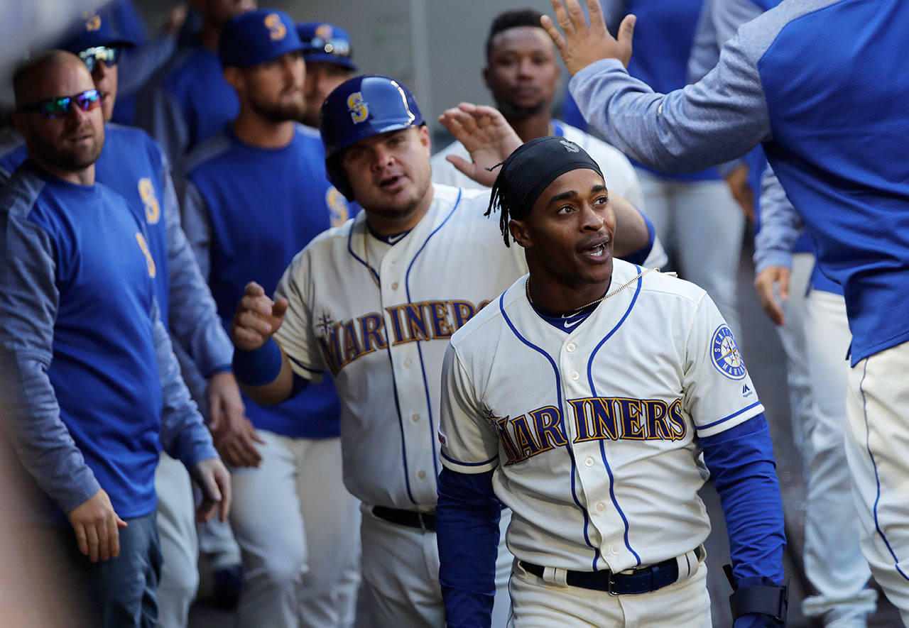 Ted S. Warren / Associated Press                                Seattle’s Mallex Smith (front) and Daniel Vogelbach (wearing helmet) are greeted in the dugout after they scored on a double by Mitch Haniger in the third inning of Sunday’s game in Seattle.