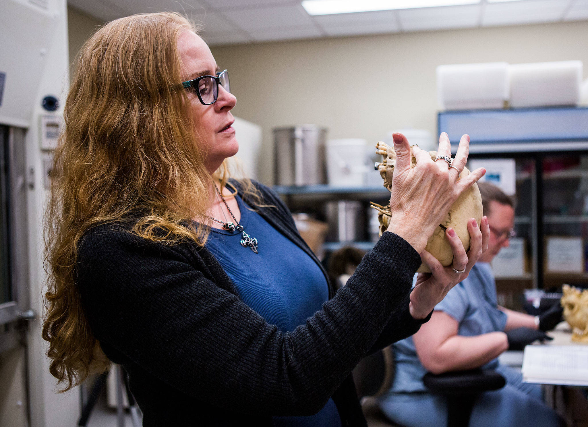 Forensic artist Natalie Murry examines a human skull for specific bone features that help her determine facial features and race of an individual while she works at the King County Medical Examiner’s Office on March 14 in Seattle. (Olivia Vanni / The Herald)