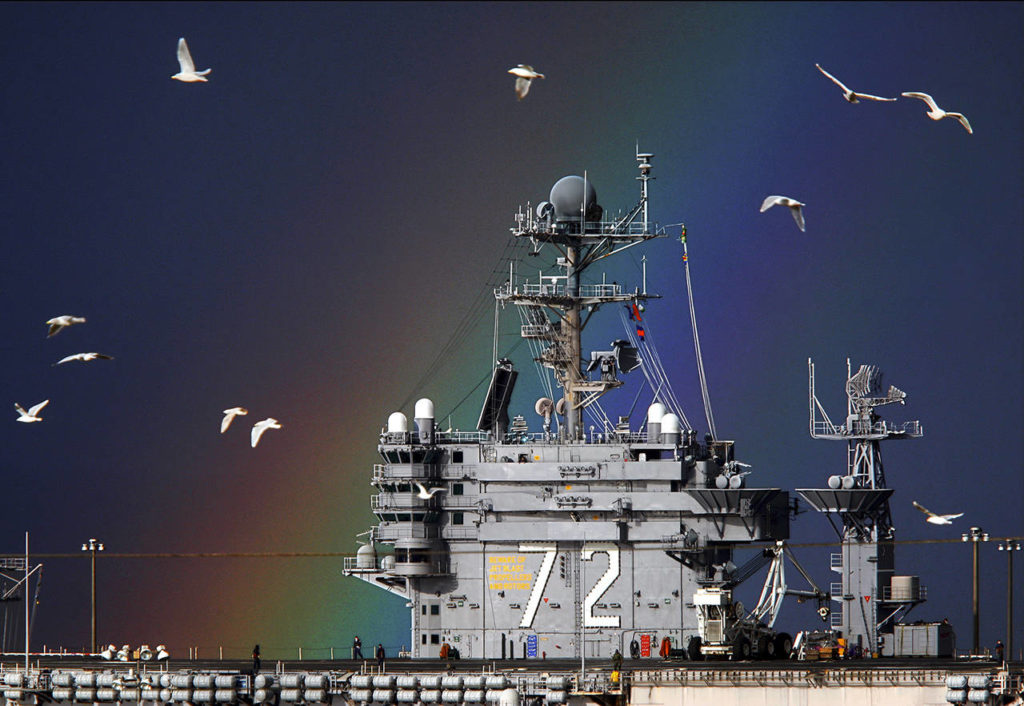 A rainbow strikes gold and gulls fill the sky near the USS Abraham Lincoln while it sits in port at Naval Station Everett in January 2010. (Dan Bates / Herald file)
