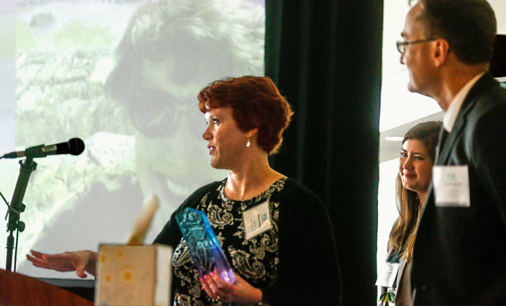 Kameon Quillen accepts the Power of One Award during the Victim Support Services lunch, Wednesday. Standing by are Craig Matheson, a deputy prosecutor, and Kimi Nolte of Victim Support Services. (Dan Bates / The Herald)
