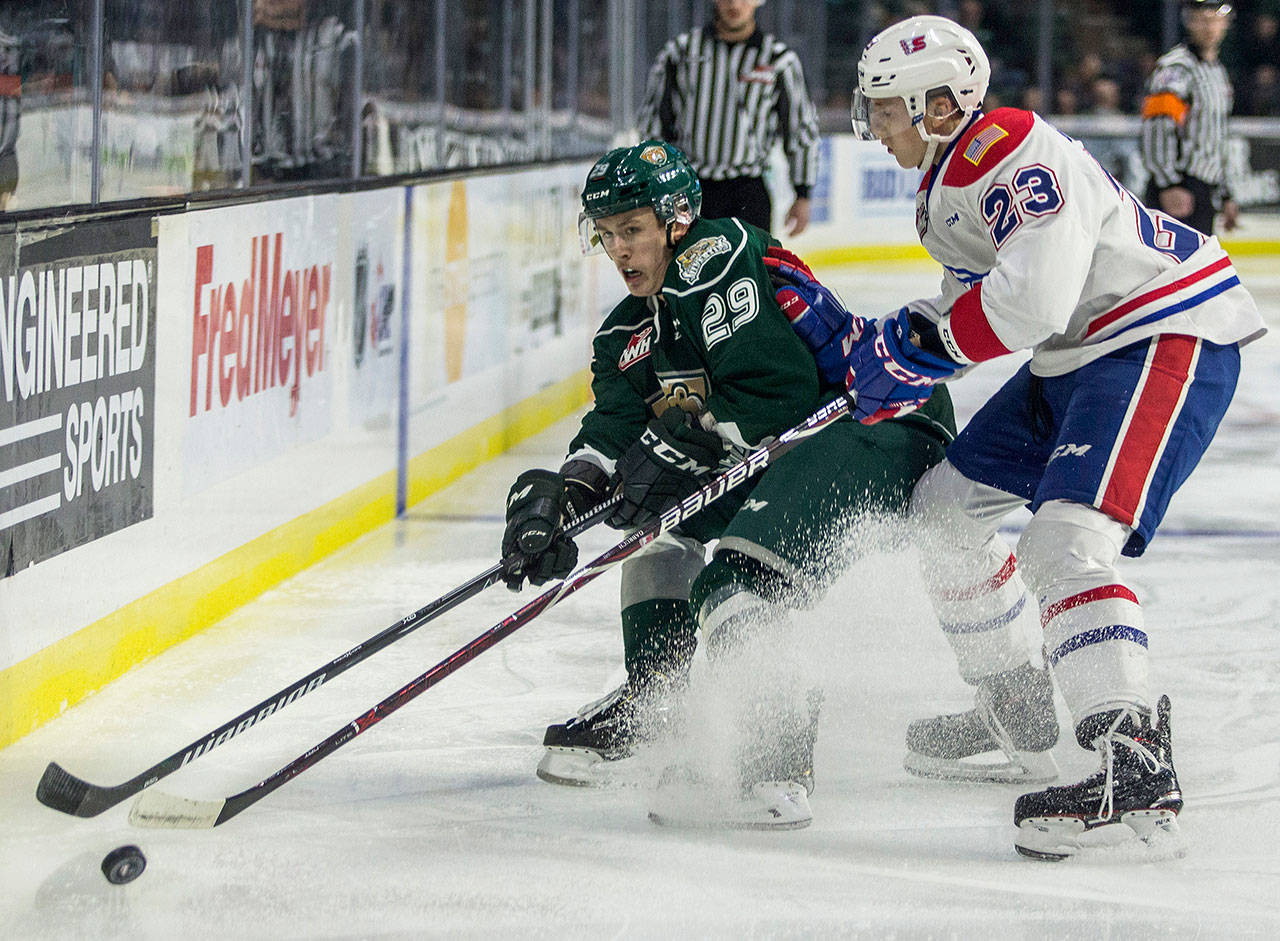 The Silvertips’ Wyatte Wylie (left) fights for the puck during the a against the Chiefs on Nov. 18, 2018, in Everett. (Olivia Vanni / The Herald)