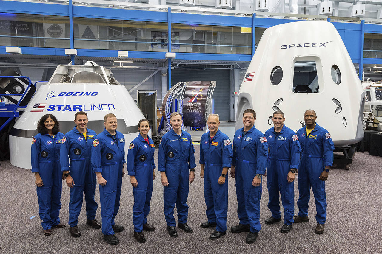 This undated photo shows mockups of Boeing’s CST-100 Starliner and SpaceX’s Crew Dragon capsules with crew members, from left, Sunita Williams, Josh Cassada, Eric Boe, Nicole Mann, Christopher Ferguson, Douglas Hurley, Robert Behnken, Michael Hopkins and Victor Glover at the Johnson Space Center in Texas. (NASA via AP, file)