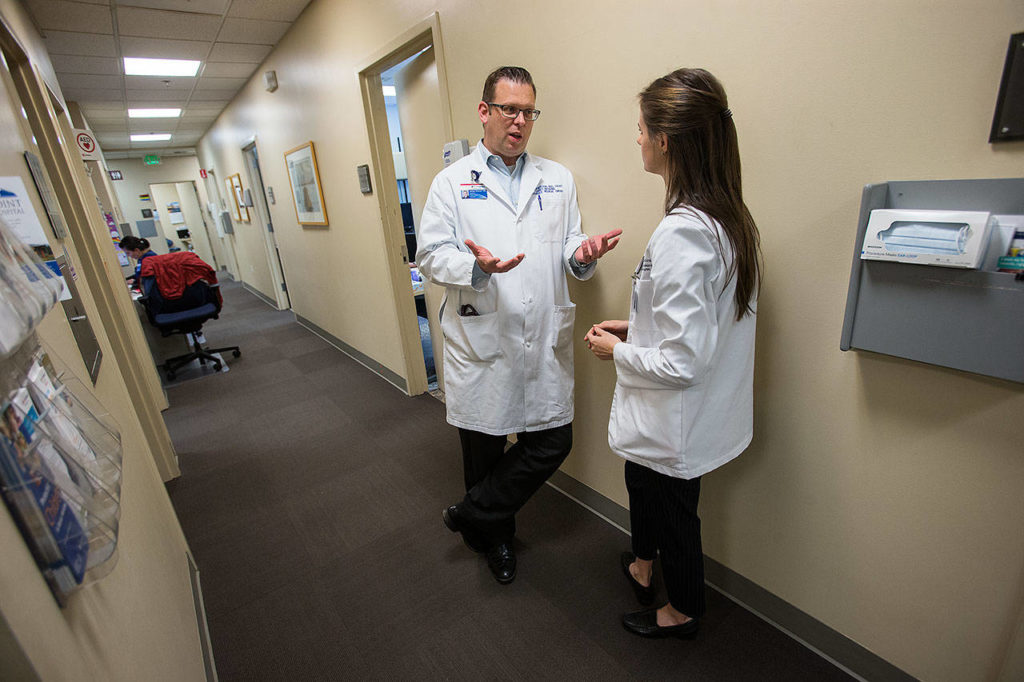 After finishing an ultrasound, Dr. Jimmy Grierson discusses a patient’s history and follow-up care with second-year WSU med student Charlotte Cronenweth at Providence Marysville on Monday. (Andy Bronson / The Herald)
