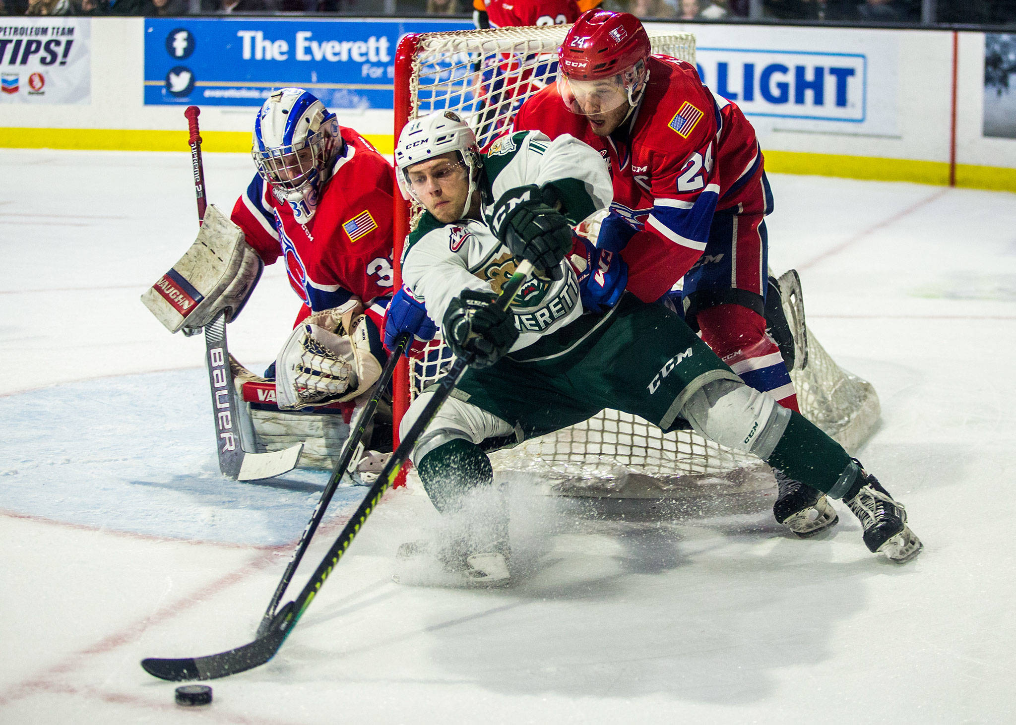 The Silvertips’ Lucas Cullen fights Spokane’s Ty Smith for the puck during a playoff game on April 6, 2019, in Everett. (Olivia Vanni / The Herald)