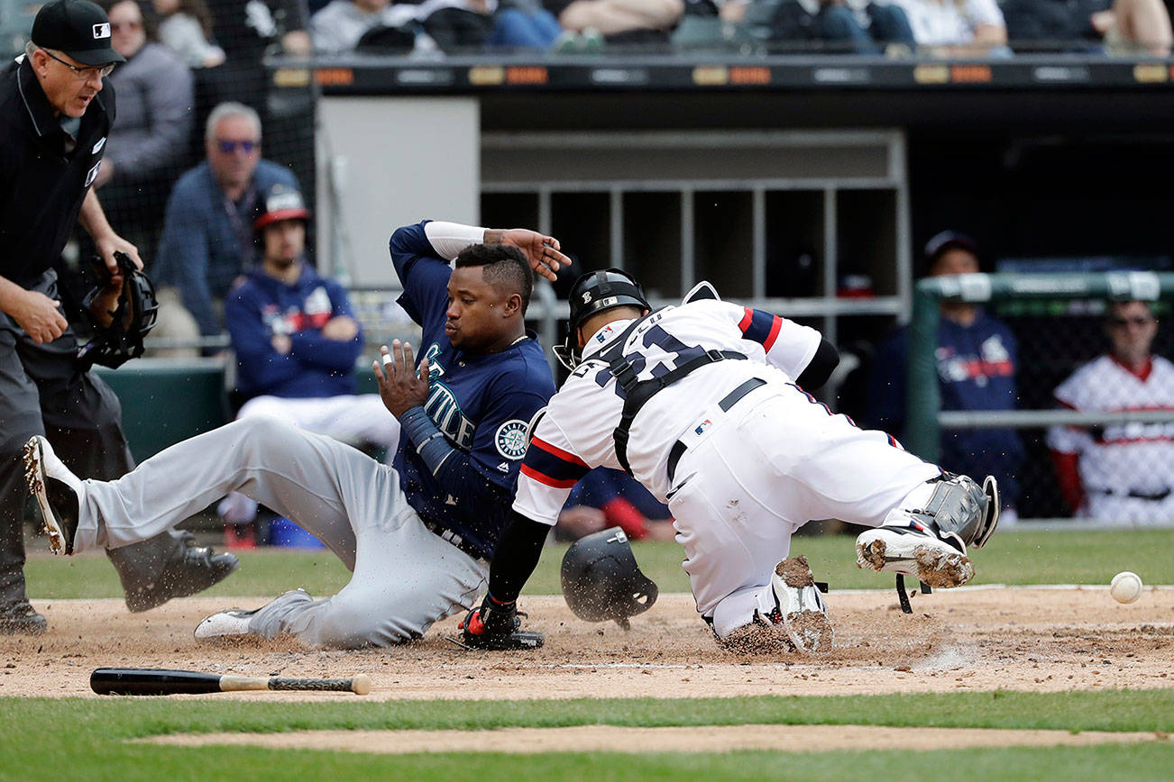 Seattle ‘s Tim Beckham scores on a three-run double by Daniel Vogelbach as the ball scoots away from White Sox catcher Welington Castillo in the third inning of Sunday’s game in Chicago. (AP Photo/Nam Y. Huh)