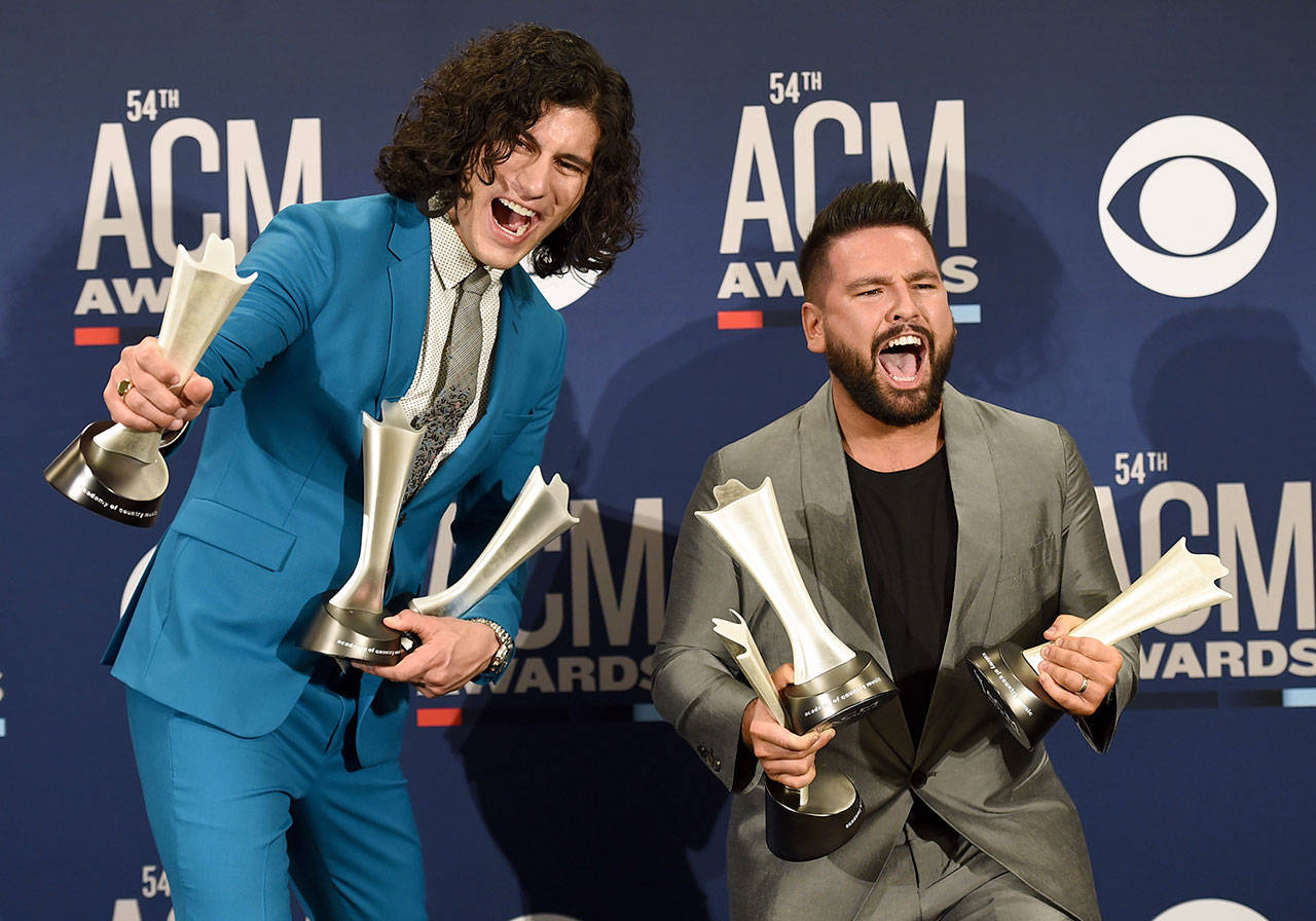 Dan Smyers (left) and Shay Mooney, of Dan + Shay, pose in the press room with the awards for song of the year and single of the year for “Tequila,” and duo of the year Sunday at the 54th annual Academy of Country Music Awards at the MGM Grand Garden Arena in Las Vegas. (Photo by Jordan Strauss/Invision/AP)