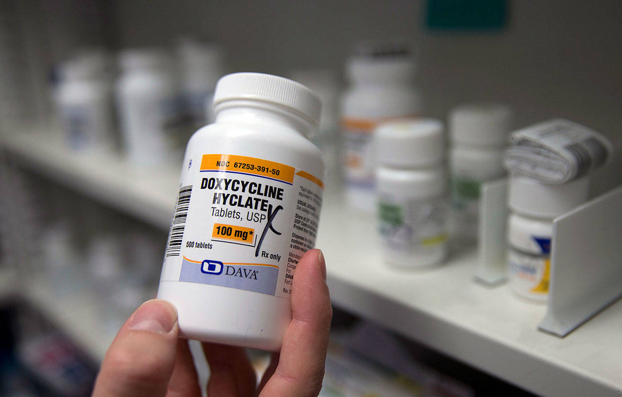 A pharmacist holds a bottle of the antibiotic doxycycline hyclate in Sacramento, California, on July 8, 2016. According to a study released Monday, sniffling, coughing kids who were seen via telemedicine visits were far more likely to be prescribed antibiotics than kids who went to a doctor’s office or clinic.
