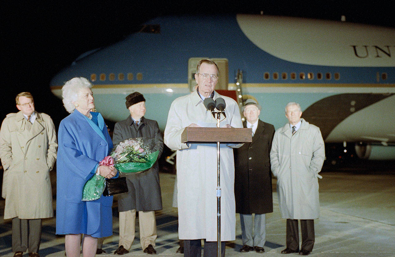 Then U.S. President George H. Bush, accompanied by first lady Barbara (left), makes farewell remarks before departing Andrews Air Force Base, Maryland, on Air Force One for a trip to Australia and Asia in 1991. (AP Photo/Greg Gibson, File)
