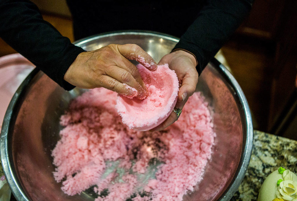 Darla Aiken packs sugar into one of her medium-sized egg molds. 
(Olivia Vanni / The Herald)
